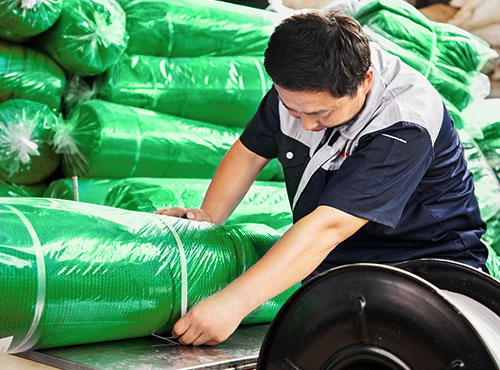 A worker is packaging net roll